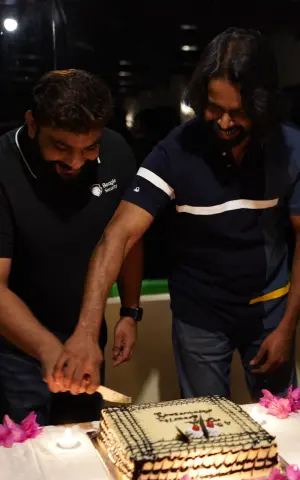 Managers cutting a cake to celebrate the company's anniversary