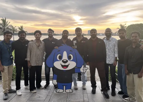 A few team members take a selfie with the Beagle Security mascot Berry.