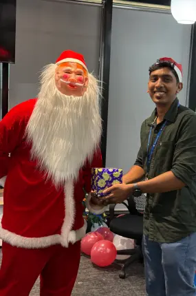 Employee posing with Santa Claus during Christmas celebration