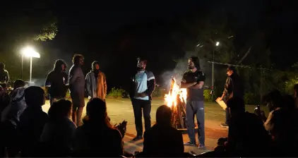 Member singing at campfire.