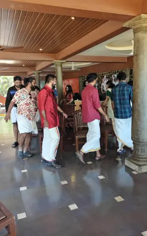 Team members participating in the traditional chair game during Onam celebrations