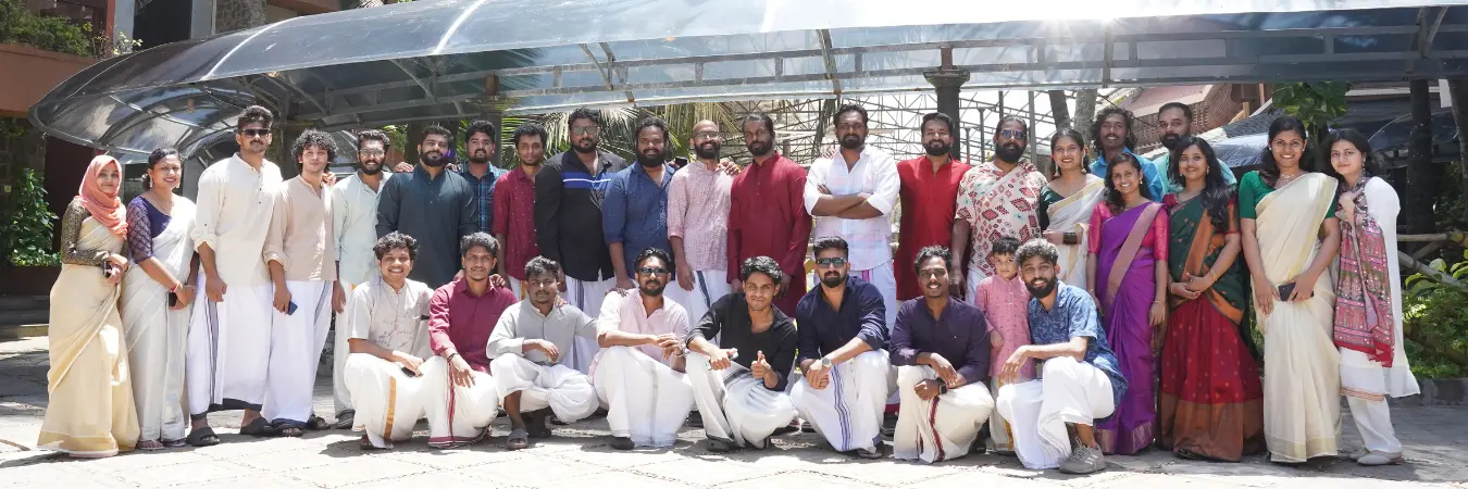 Team members in traditional wear posing for a group photo.