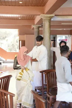 Team members participating in the traditional chair game during Onam celebrations