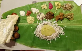 Traditional Onam Sadhya served on a banana leaf with a variety of colorful vegetarian dishes and rice.