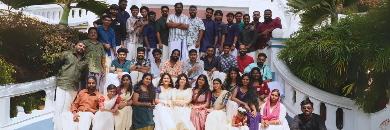 Team members in traditional wear posing for a group photo.