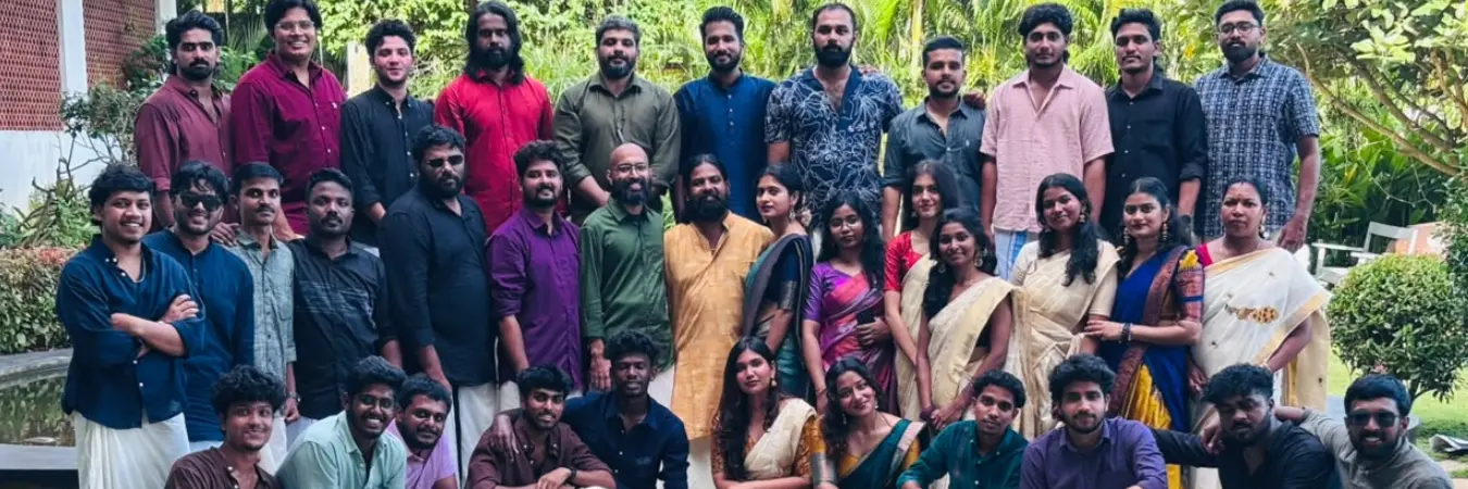 Team members in traditional wear posing for a group photo.