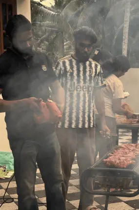 Team members getting the grill ready with the help of a blower.