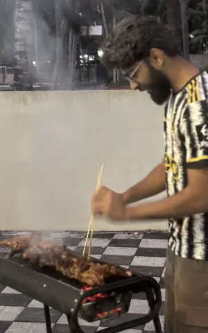 A team member helping out by grilling the chicken.