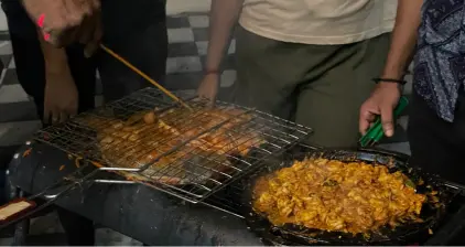 Prawns and fish being cooked on the grill.