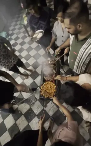 The team huddling around the grill, cooking the fish.