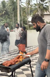 Setting the chicken on the flaming grill.